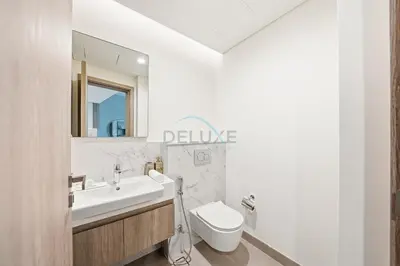 a bathroom with a sink and a toilet and a mirror at High-Floor 1BR Facing the Marina and City, Minutes from Marina Beach with Easy Access to Marine Transport, LIV Marina, Dubai Marina by Deluxe Holiday Homes in Dubai