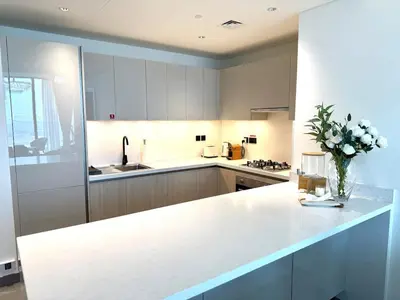 a kitchen with a white counter and a vase of flowers at Spacious apartment with Burj Khalifa view close to Dubai mall! in Dubai