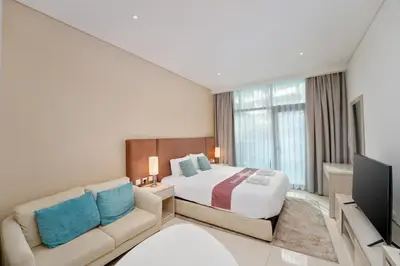 a hotel room with a bed and a couch at Seven Palm Residence with Beach access in Dubai