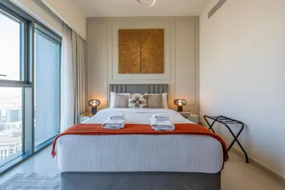 a bedroom with a large bed and a large window at Stunning 1 Bedroom Panoramic Views at Burj Royale in Dubai