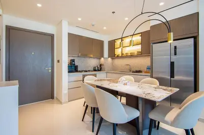 a kitchen with a table and chairs and a refrigerator at Skyline Serenity - Luxury Beachfront Living in Dubai