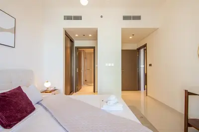 a bedroom with a white bed and a hallway at Skyline Serenity - Luxury Beachfront Living in Dubai