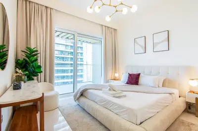 a white bedroom with a bed and a window at Skyline Serenity - Luxury Beachfront Living in Dubai