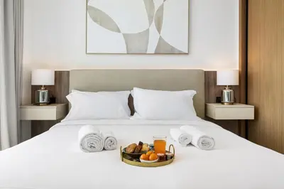 a bed with a tray of fruit and towels at BLVD Luxury 2BHK with Private Pool Near Circle Mall in Dubai