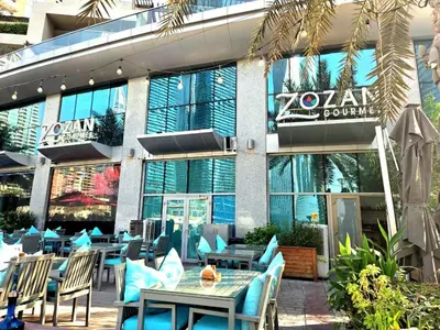 a restaurant with tables and chairs in front of a building at Marina Residence tower A in Dubai