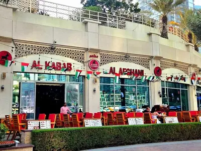 a restaurant with red chairs in front of a building at Marina Residence tower A in Dubai