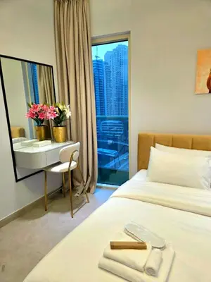 a hotel room with a bed and a desk with flowers at Marina Residence tower A in Dubai