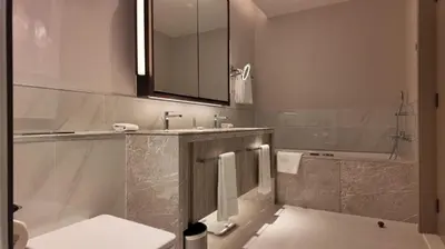 a bathroom with a sink and a mirror and a tub at Address Point Tower 2 in Dubai