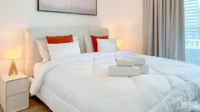 a white bedroom with a large white bed with pillows at MARINA DIAMOND 6 by Design Studio in Dubai