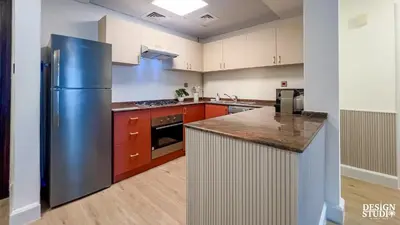 a kitchen with a stainless steel refrigerator and red cabinets at MARINA DIAMOND 6 by Design Studio in Dubai