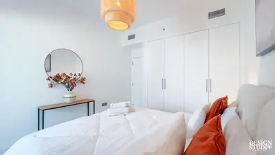 a white bedroom with a bed and a mirror at MARINA DIAMOND 6 by Design Studio in Dubai