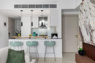 a kitchen and living room with a counter and stools at Modern 2BR Luxury Apartment with Downtown Dubai & Burj Khalifa Views in Dubai