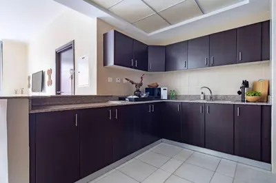 a kitchen with black cabinets and a sink at Frank Porter - Torch Tower Marina in Dubai