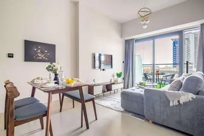 a living room with a table and a couch and a dining room at Frank Porter - Golf Gate 1 in Dubai