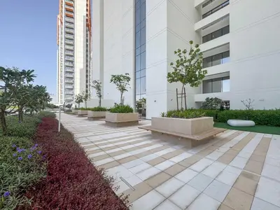 a walkway with benches in front of a building at Frank Porter - Golf Gate 1 in Dubai