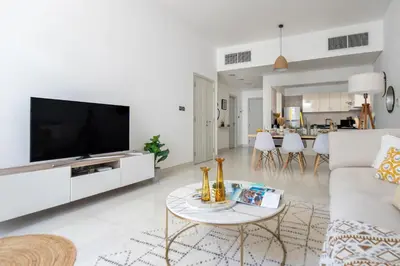 a living room with a couch and a tv at Frank Porter - Polo Residence C5 in Dubai