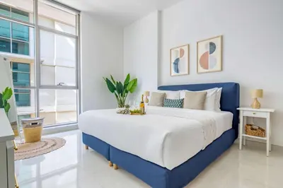 a blue and white bedroom with a large bed at Frank Porter - Polo Residence C5 in Dubai