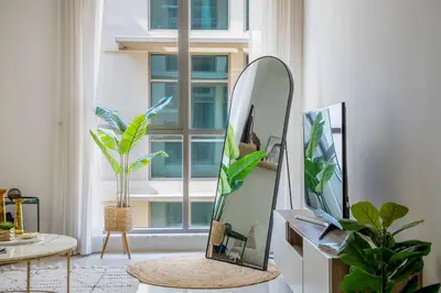 a mirror sitting on a table next to a window at Frank Porter - Polo Residence C5 in Dubai