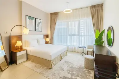 a hotel room with a bed and a window at Luxury Apartment Fully Furnished Jumeirah Garden City in Dubai