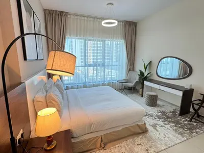 a bedroom with a large bed and a window at Luxury Apartment Fully Furnished Jumeirah Garden City in Dubai