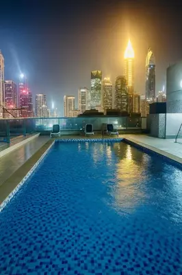 a swimming pool on top of a building with a city skyline at Luxury Apartment Fully Furnished Jumeirah Garden City in Dubai