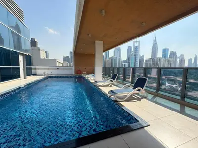a pool on the top of a building with a view of the city at Luxury Apartment Fully Furnished Jumeirah Garden City in Dubai