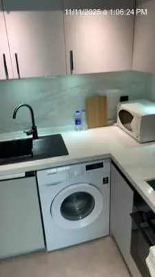 a kitchen with a washing machine and a sink at MARINA VIEW TOWER a WING in Dubai