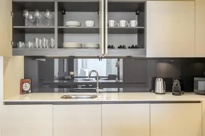 a kitchen with white cabinets and a sink at Blueground DIFC pool gym DXB-505 in Dubai