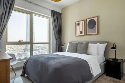 a bedroom with a bed and a large window at Blueground Icon Tower city view gym parking DXB-1332 in Dubai