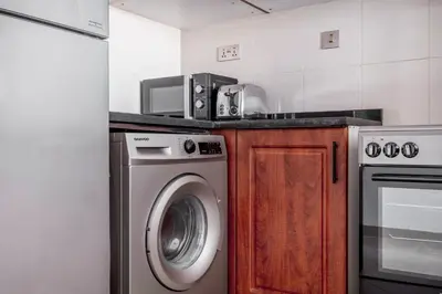 a kitchen with a washing machine and a microwave at Blueground Icon Tower city view gym parking DXB-1332 in Dubai
