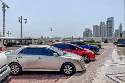 a row of parked cars in a parking lot at Blueground Icon Tower city view gym parking DXB-1332 in Dubai