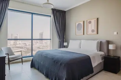 a bedroom with a bed and a large window at Blueground JLT pool gym nr Marina JBR DXB-1616 in Dubai