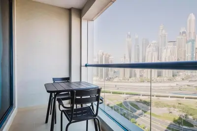 a table and two chairs in a room with a large window at Blueground JLT pool gym nr Marina JBR DXB-1616 in Dubai