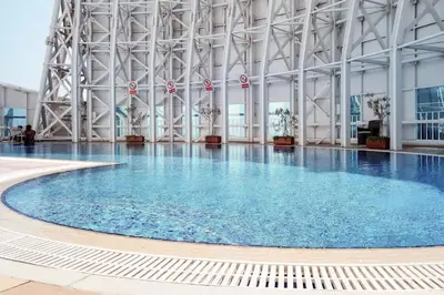 a large swimming pool with blue water in a building at Blueground JLT pool gym nr Marina JBR DXB-1616 in Dubai