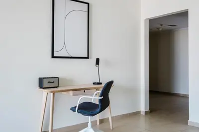 a desk with a chair and a mirror on a wall at Blueground JLT pool gym nr Marina JBR DXB-1616 in Dubai