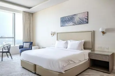 a bedroom with a large white bed and a blue chair at Blueground The Palm Jumeirah pool nr Atlantis DXB-1712 in Dubai