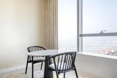 a table and two chairs in a room with a window at Blueground The Palm Jumeirah pool nr Atlantis DXB-1712 in Dubai