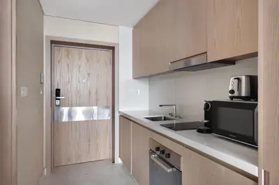 a kitchen with a door and a television and a counter at Blueground The Palm Jumeirah jacuzzi nr Atlantis DXB-1708 in Dubai