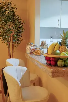 a kitchen with a counter with chairs and a bowl of fruit at Rare apt with views of both Marina and JBR wheel in Dubai