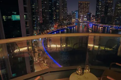 a view of a city at night from a balcony at Rare apt with views of both Marina and JBR wheel in Dubai