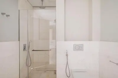 a white bathroom with a shower and a glass door at Blueground The Palm Jumeirah pool nr Atlantis DXB-1717 in Dubai