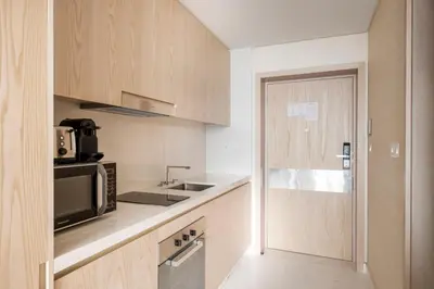 a kitchen with wooden cabinets and a microwave at Blueground The Palm Jumeirah pool nr Atlantis DXB-1717 in Dubai