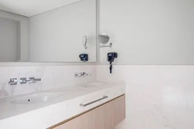 a white bathroom with a sink and a mirror at Blueground The Palm Jumeirah pool nr Atlantis DXB-1719 in Dubai