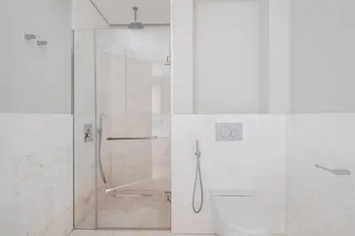 a white bathroom with a shower and a toilet at Blueground The Palm Jumeirah jacuzzi nr Atlantis DXB-1720 in Dubai
