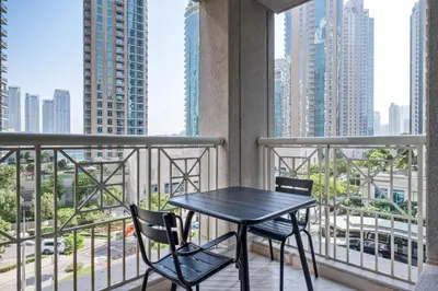 a table and chairs on a balcony with a view of a city at Blueground Downtown Dubai pool nr Burj Khalifa DXB-1735 in Dubai