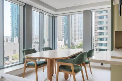 a dining room with a table and chairs and large windows at Blueground Downtown Dubai pool nr Burj Khalifa DXB-1735 in Dubai