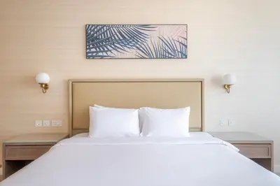 a bed with white pillows in a hotel room at Blueground The Palm Jumeirah pool nr Atlantis DXB-1722 in Dubai