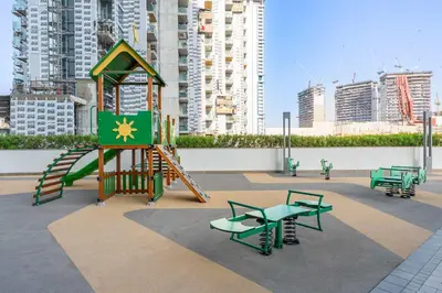 a playground with a slide and benches in a city at StayShort - Modern 1 Bed in Meydan Sleeps 4 in Dubai