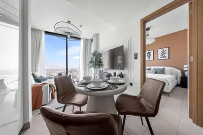 a room with a table and chairs and a bedroom at StayShort - Modern 1 Bed in Meydan Sleeps 4 in Dubai