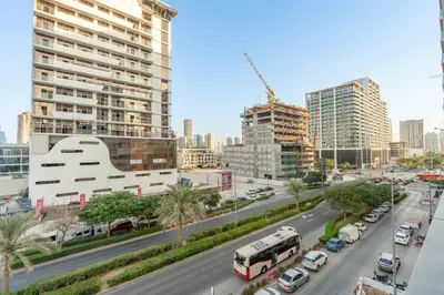 a city street with cars and a bus on the road at StayShort - Chic Studio Apartment in JVC Sleeps 4 in Dubai